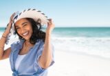 Pessoa protegida do sol em uma praia, imagem ilustrativa para a notícia sobre o Tinosorb S