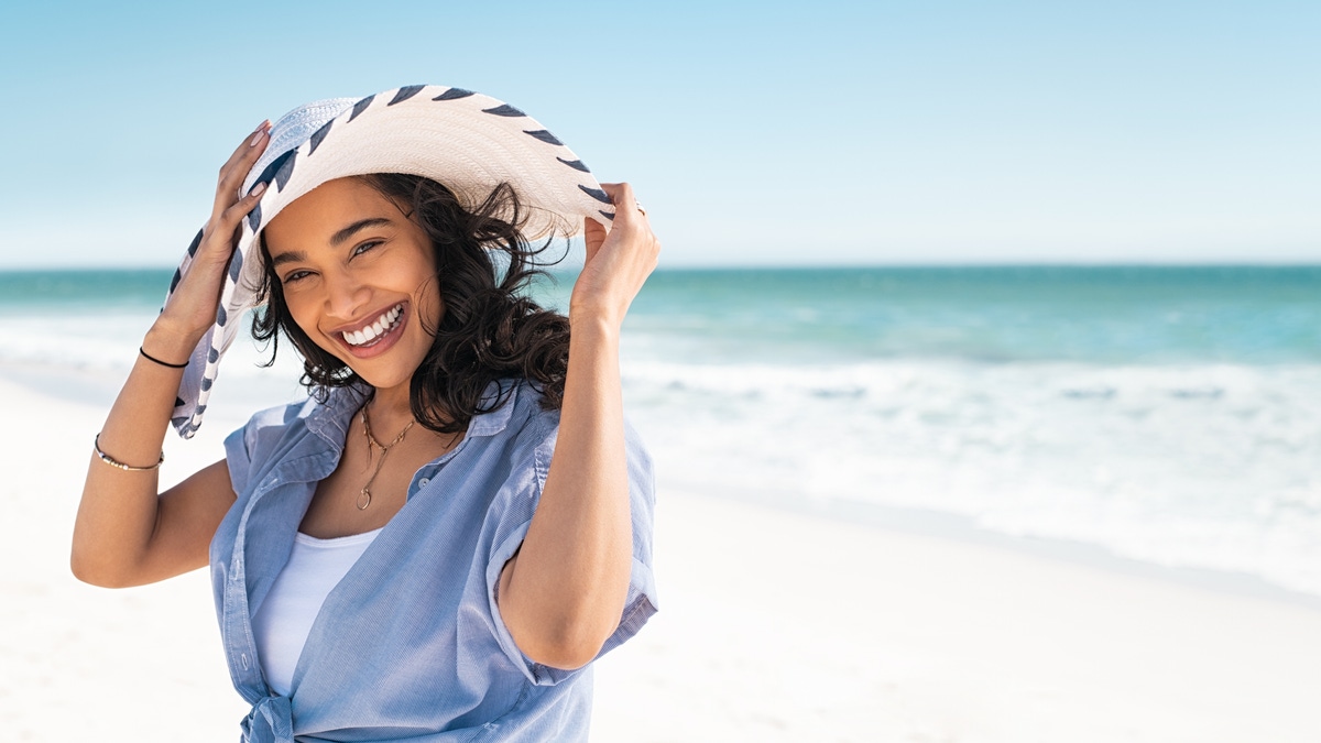 Pessoa protegida do sol em uma praia, imagem ilustrativa para a notícia sobre o Tinosorb S