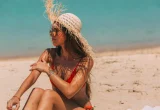 Protetor solar e chapéu na praia, em dia ensolarado