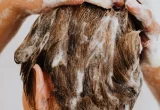 Pessoa lava o couro cabeludo com espuma de shampoo