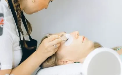 Profissional aplicando produto próximo aos cílios de uma cliente