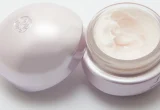 Creme corporal em pote aberto com textura branca