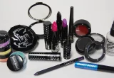 Produtos de maquiagem, incluindo base facial, batons, máscara e blush, sobre fundo claro.