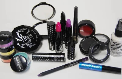 Produtos de maquiagem, incluindo base facial, batons, máscara e blush, sobre fundo claro.