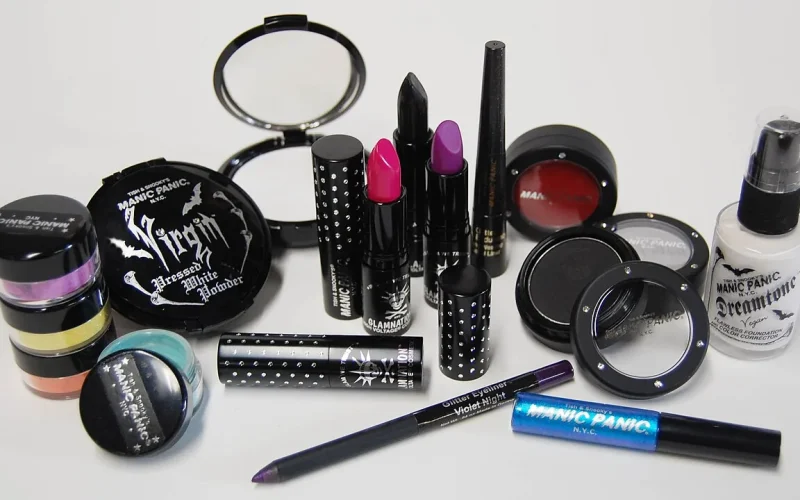 Produtos de maquiagem, incluindo base facial, batons, máscara e blush, sobre fundo claro.
