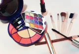 Produtos de maquiagem, incluindo lápis cosméticos e pincéis, sobre uma superfície clara.