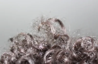 Textura de cabelo cacheado em close para ilustrar a escolha de mousse capilar.