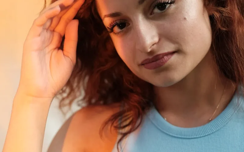 Pessoa com cabelo ondulado em retrato, representando o uso de finalizadores para modelagem