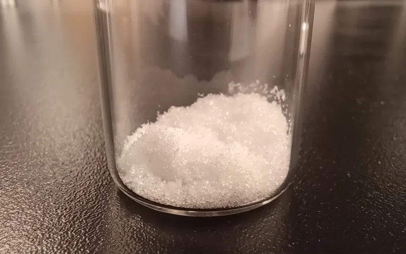 Cristais de ácido glicólico em um frasco de laboratório