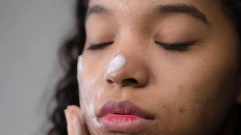 Pessoa aplicando limpador facial com movimentos suaves