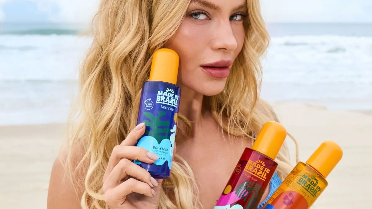Pessoa segura os três body mists da linha Made in Brazil da Ciclo em uma praia