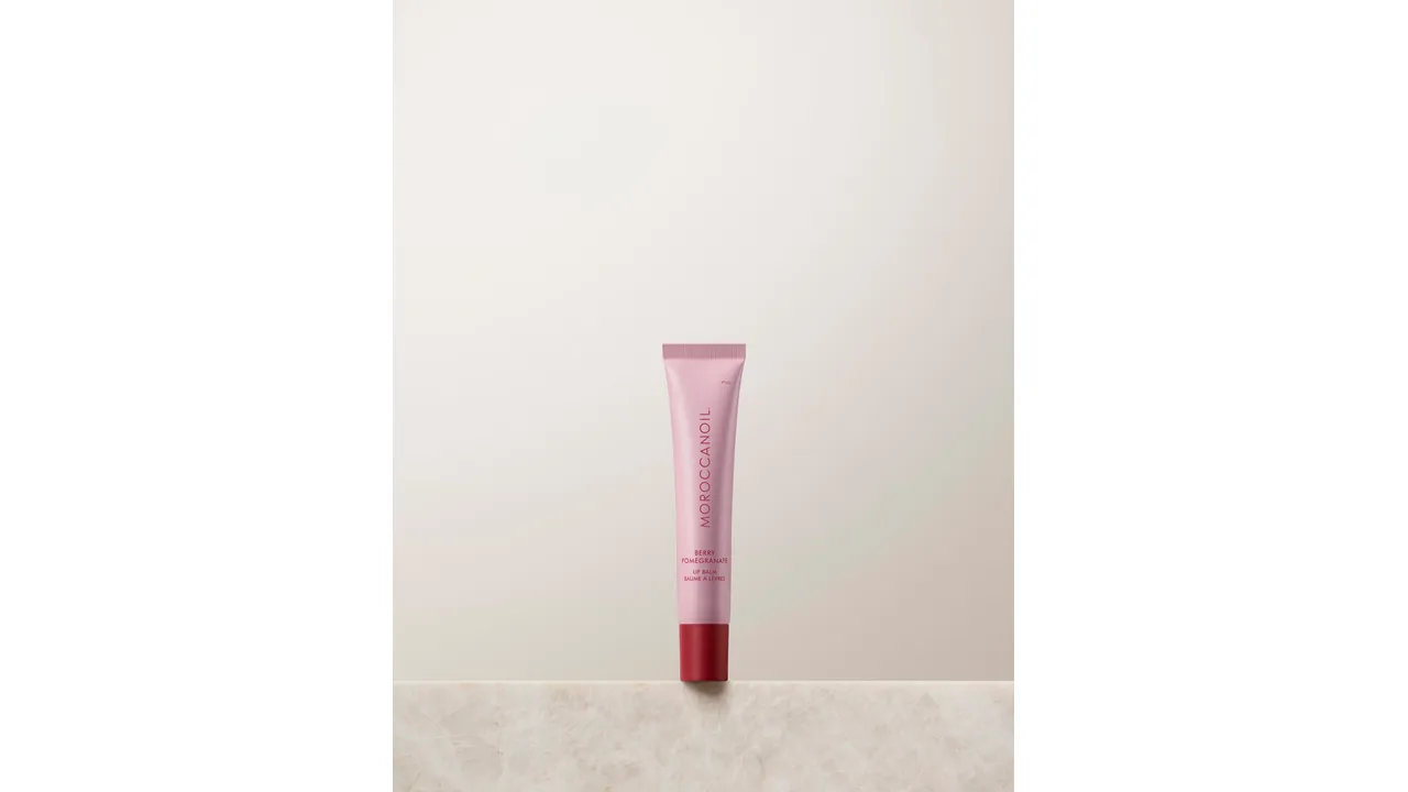 Balm labial Berry Pomegranate da Moroccanoil, com tonalidade de frutas vermelhas.