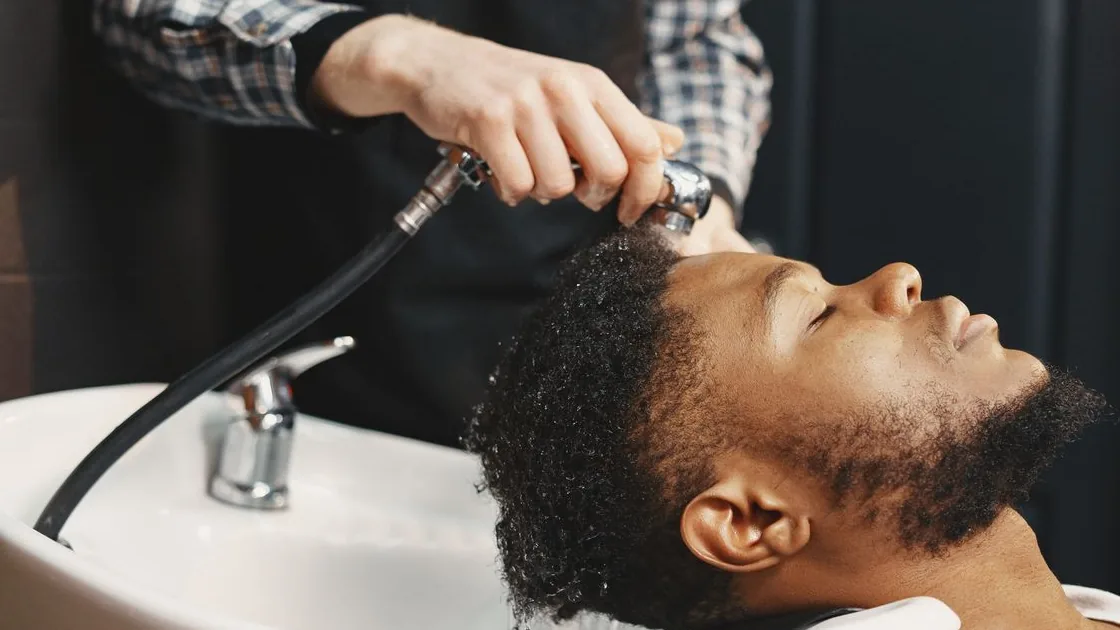 Pessoa recebe lavagem do cabelo em um lavatório de salão