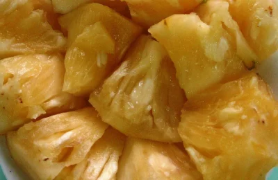 Pedaços de abacaxi fresco em um prato, imagem relacionada à bromelina usada em algumas fórmulas cosméticas