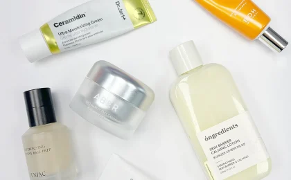 Frascos de cosméticos coreanos sobre fundo claro, imagem ilustrativa de skincare facial
