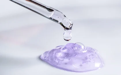 Pipeta libera uma gota de sérum sobre um gel em laboratório cosmético