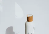 Frasco de cosmético branco sobre superfície clara, imagem ilustrativa para guia de cosméticos sem fragrância