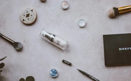Paleta, pincéis e produtos de maquiagem sobre uma superfície clara
